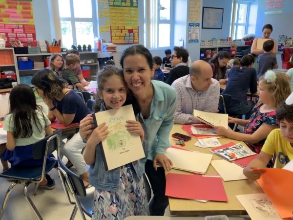 An Oyster Adams second grade student holds up her book about dogs.