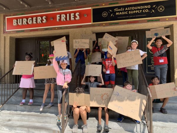 826DC students hold up environmental protest signs.